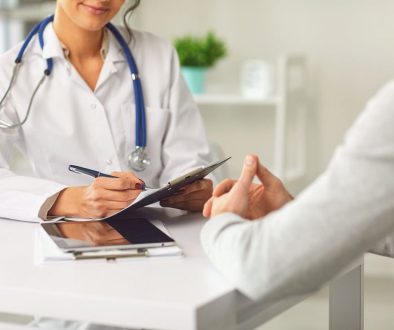 Female doctor therapist gross allergist nutritionist otolaryngologist and male patient sitting at a table in a clinic office